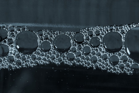 steel blue water with bubbles under glass bottle, dark color