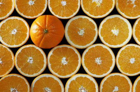 oranges halves background with one whole, on blackの写真素材