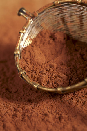 cocoa powder in old rustic style silver sieve, shallow dof