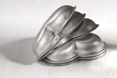 heart cake tin trays stacked on white wood table, shallow dofの写真素材