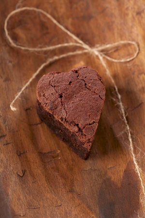 chocolate brownie heart with bow, rough wooden backgroundの写真素材