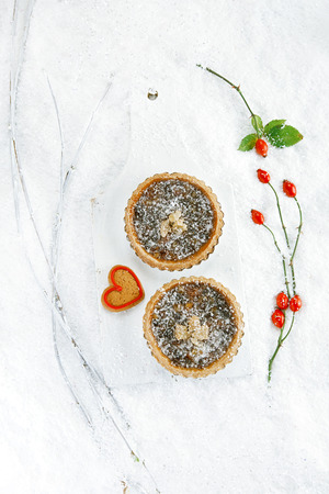 christmas  tart with mincemeat and candied peel on white snow festive backgroundの写真素材