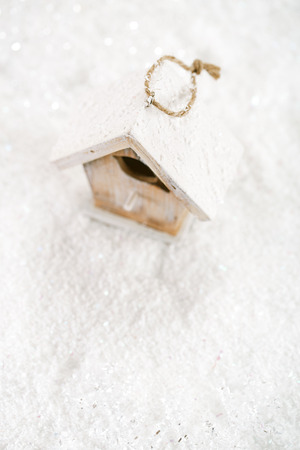 wooden bird house christmas decoration on white snow backgroundの写真素材