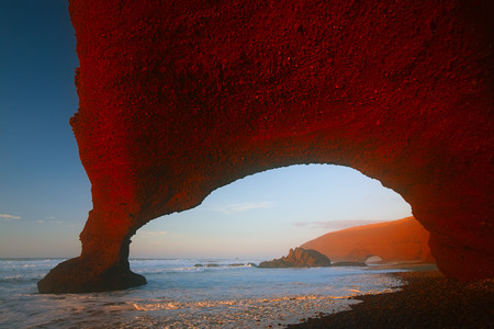 Legzira dramatic natural stone arches reaching over the sea in sunset, Atlantic Ocean, Morocco, Africaの写真素材