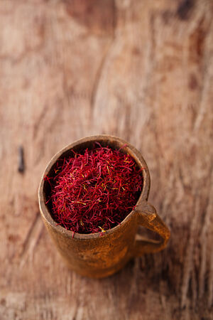 saffron spice in antique wooden mug on old wood background, closeupの写真素材