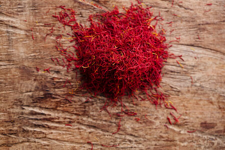 saffron spice in pile on old wooden background, closeupの写真素材
