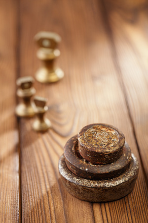 Vintage  iron and brass kitchen  weights on old wooden tableの写真素材