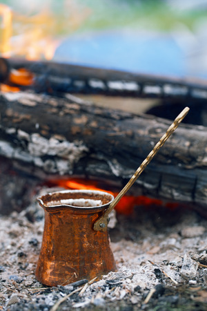Making coffee in the fireplace  on camping or hiking in the natureの写真素材