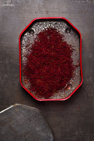saffron spice threads   in vintage  old tin,  old metal background, closeupの写真素材