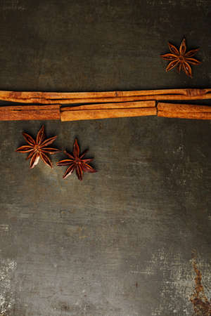 Cinnamon sticks and anise star on dark metal backgroundの写真素材