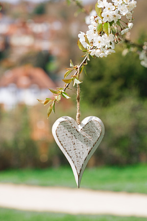 wooden heart in Spring with blossom cherry flower sakuraの写真素材