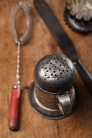 Vintage  Baking utensils - sifter, whisk, spatula, tins and moulds on wooden board