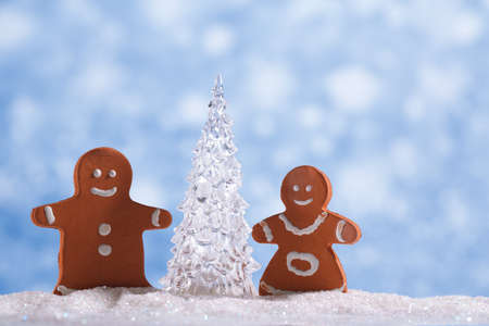 gingerbread boy and girl  with Shinny Glass Christmas Tree, abstract snow blue backgroundの写真素材