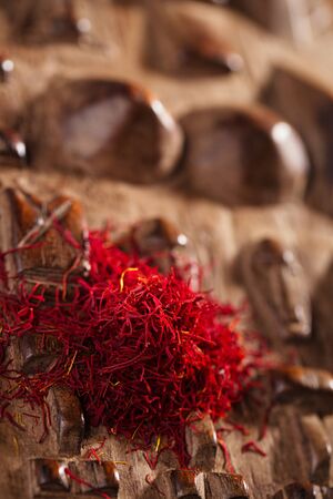 saffron spice in pile on carved wooden backgroundの写真素材