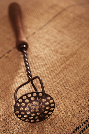 real vintage iron with wooden handle potato mashers on old grain sacking linen Completely hand made  handwoven and homespunの写真素材