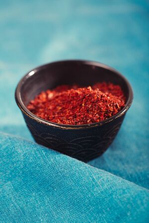 chipotle jalapeno smoked chili flakes in vintage mould tin on textured woden backgroundの写真素材