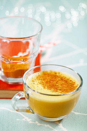 Turmeric latte or golden milk with spice mix, the drink is made by steaming milk with aromatic turmeric powder and spicesの写真素材