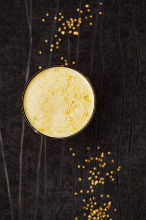 Turmeric latte or golden milk with glitter stars , The drink is made by steaming milk with aromatic turmeric powder and spicesの写真素材