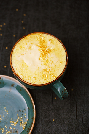 Turmeric latte or golden milk , The drink is made by steaming milk with aromatic turmeric powder and spicesの写真素材