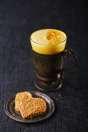 Turmeric latte or golden milk , The drink is made by steaming milk with aromatic turmeric powder and spicesの写真素材