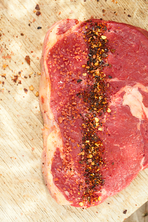 chipotle flakes chilli spice and rose sea salt  with bbq raw beef steak on wooden boardの写真素材