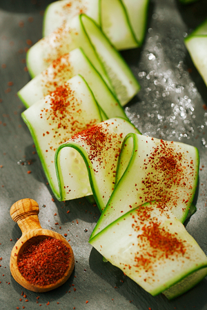 Ground Red Sumac Berries sprinkled on cucumber sliceの写真素材