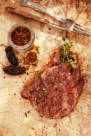beef steak with chipotle chilli flakes on woodの写真素材