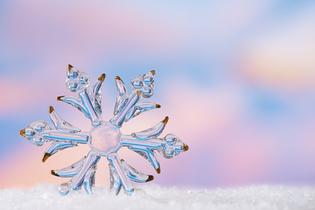 glitter christmas glass snowflake bauble  on  beach with seascape backgroundの写真素材