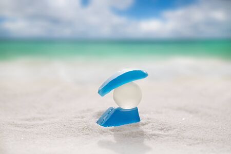 sea glass on white sand beach with seascapeの写真素材