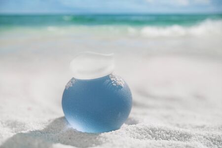 sea glass on white sand beach with seascapeの写真素材