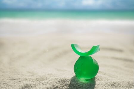 sea glass on white sand beach with seascapeの写真素材