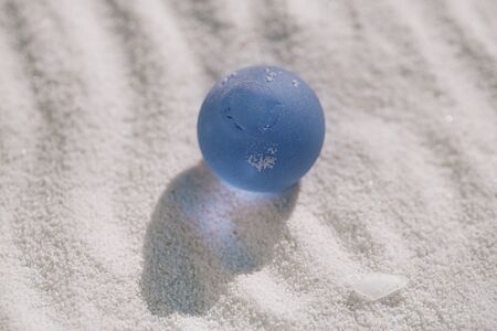 sea glass on white sand beach with seascapeの写真素材