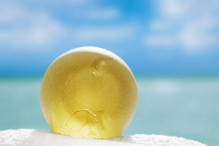 sea glass on white sand beach with seascapeの写真素材