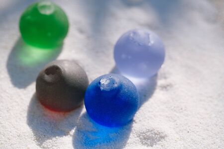 sea glass on white sand beach with seascapeの写真素材