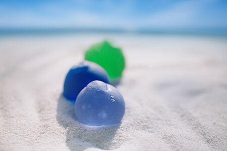 sea glass on white sand beach with seascapeの写真素材