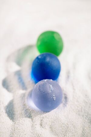 sea glass on white sand beach with seascapeの写真素材