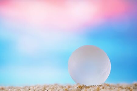 sea glass ball on  beach sand  with ocean underwater seascapeの写真素材