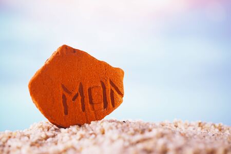 sea glass stone  on  beach sand  with seascape backgroundの写真素材