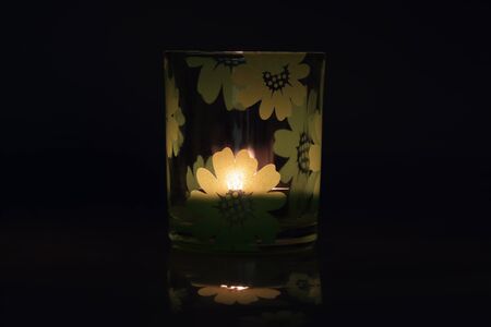 A glass with a lit candle.の写真素材