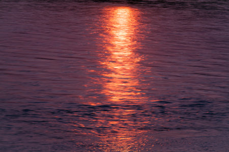 Red sun track on water. The surface of the river.