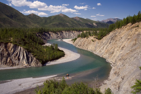 The view from the mountain slope to the river with green water. River Omulevka, Magadan Oblast,...