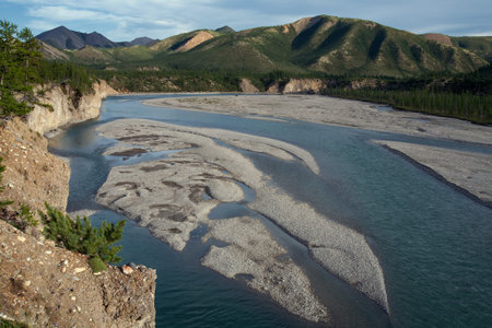 View from the steep bank of the river in the mountains. River Omulevka. Magadan Region. Russia.