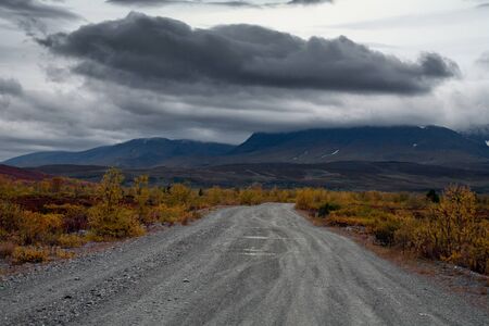 The road to the mountains and a dark cloud over the mountains. Polar Urals. Russia.の写真素材