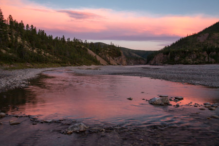 Red light from the sunset in the valley. River Omulevka. Yakutia. Russia.の写真素材