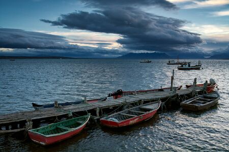 Boats at the pier and ships at sea. Puerto Natales. Chile.の写真素材