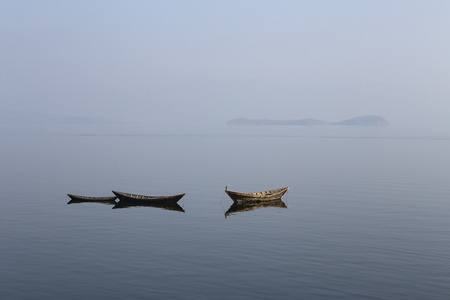 Wooden boat on the calm surface of the lake. Chivyrkuisky Bay. The Lake Baikal. Buryatia. Russia.の写真素材