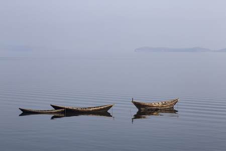 Wooden boat on the calm surface of the lake. Chivyrkuisky Bay. The Lake Baikal. Buryatia. Russia.の写真素材