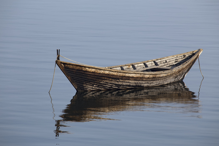 Wooden boat on the calm surface of the lake. Chivyrkuisky Bay. The Lake Baikal. Buryatia. Russia.の写真素材