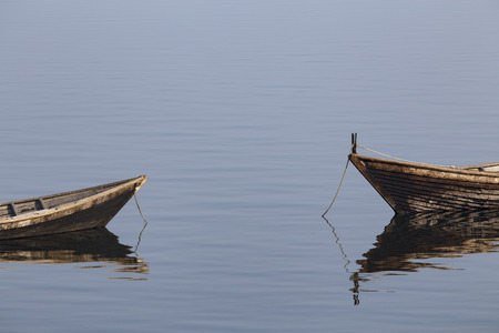Wooden boat on the calm surface of the lake. Chivyrkuisky Bay. The Lake Baikal. Buryatia. Russia.の写真素材