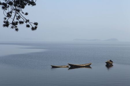 Wooden boat on the calm surface of the lake. Chivyrkuisky Bay. The Lake Baikal. Buryatia. Russia.の写真素材